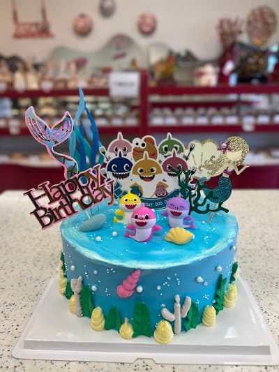 Blue birthday cake decorated with sea creatures and character toppers